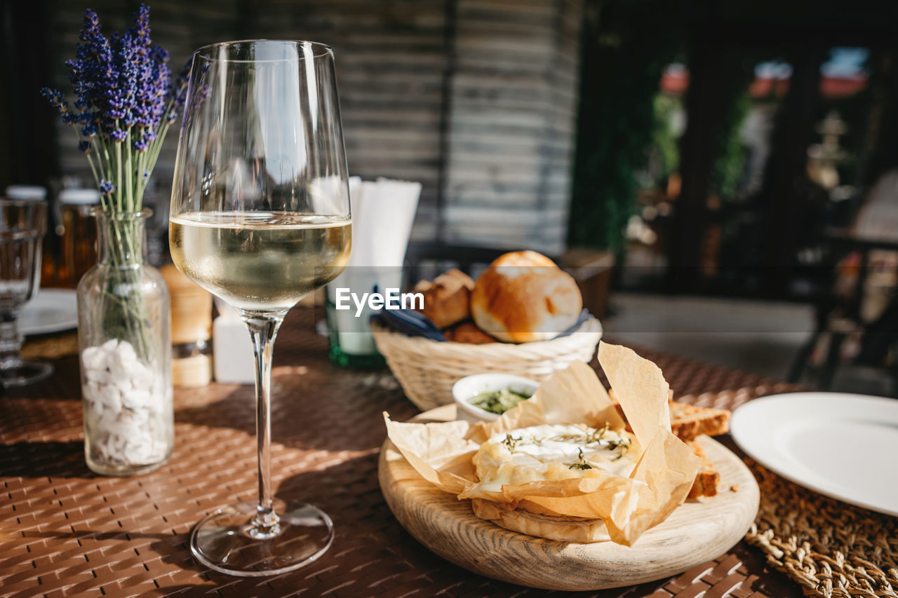 Glass of cold white wine and oven baked camembert cheese