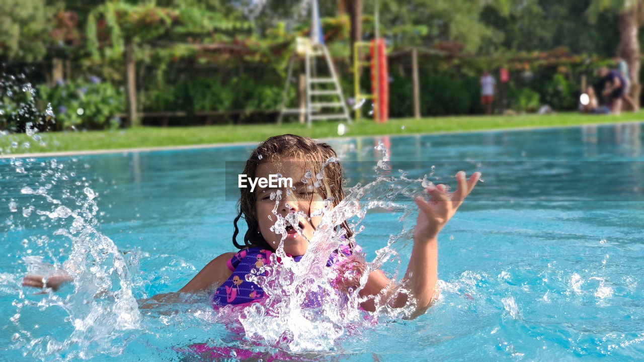 Girl splashing in the pool