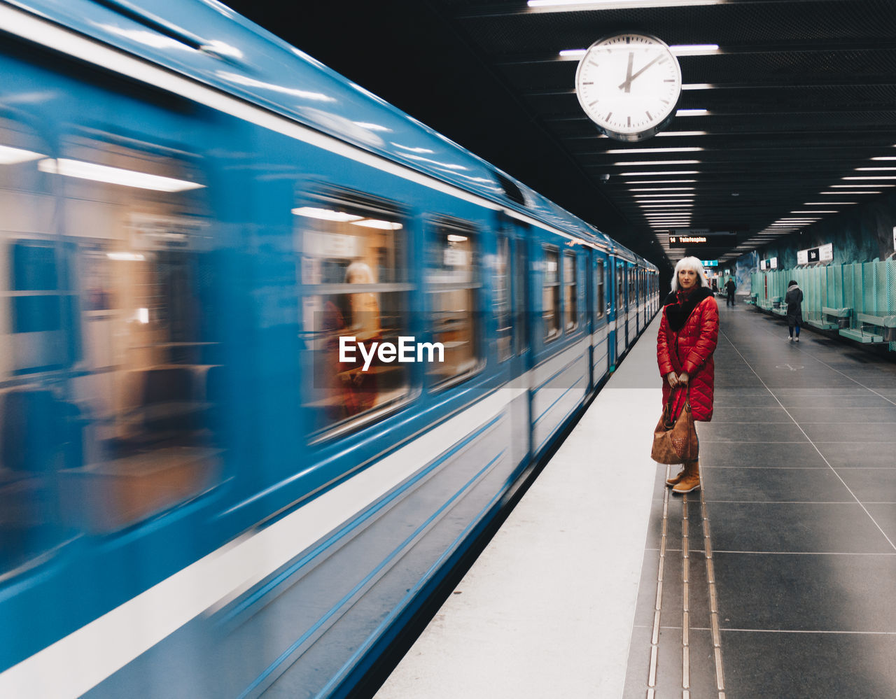 Woman standing by train at railroad station platform