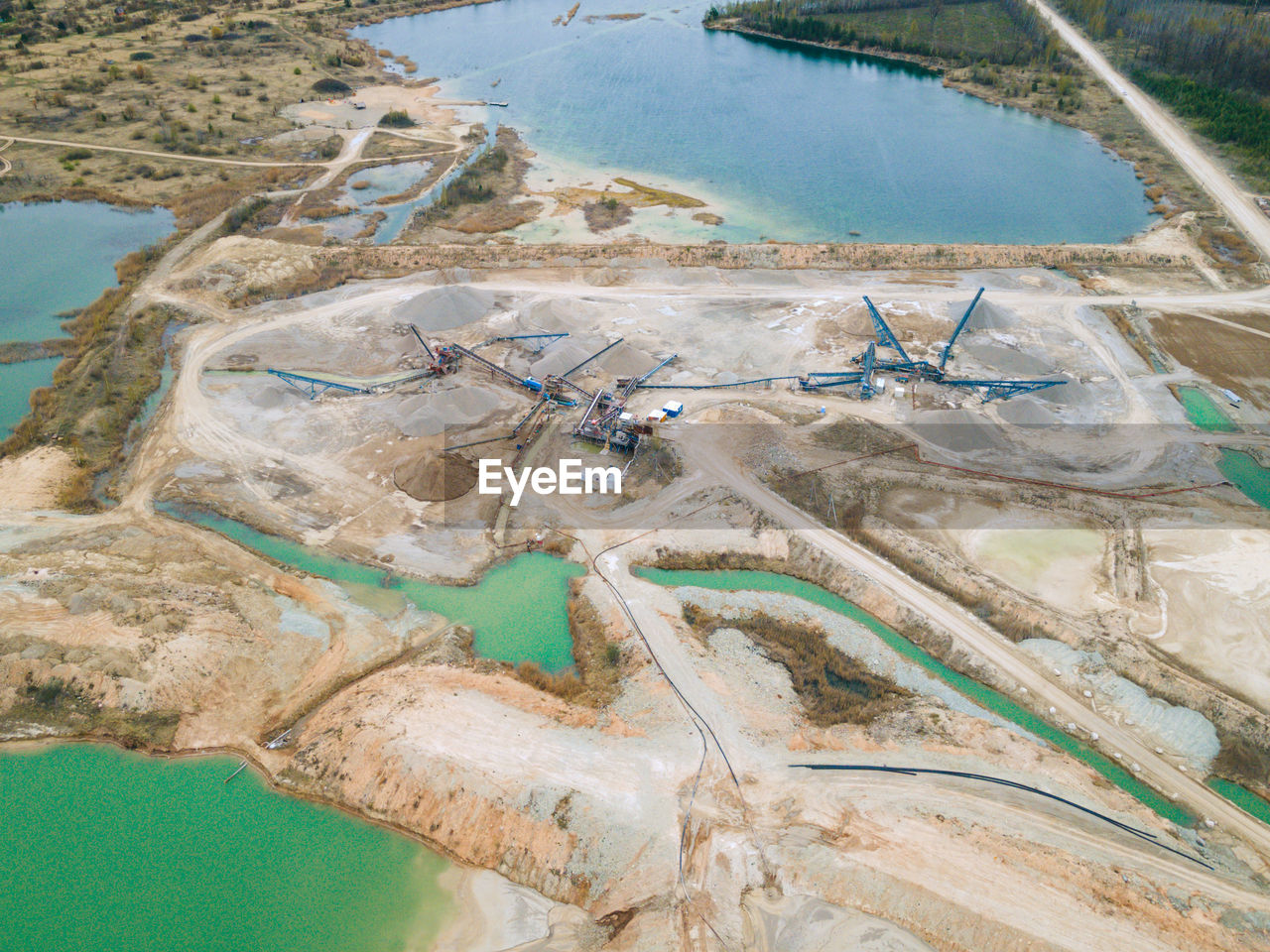 Aerial view of sand and stone quarry with tortoise color water lakes and ponds. industry of mining.