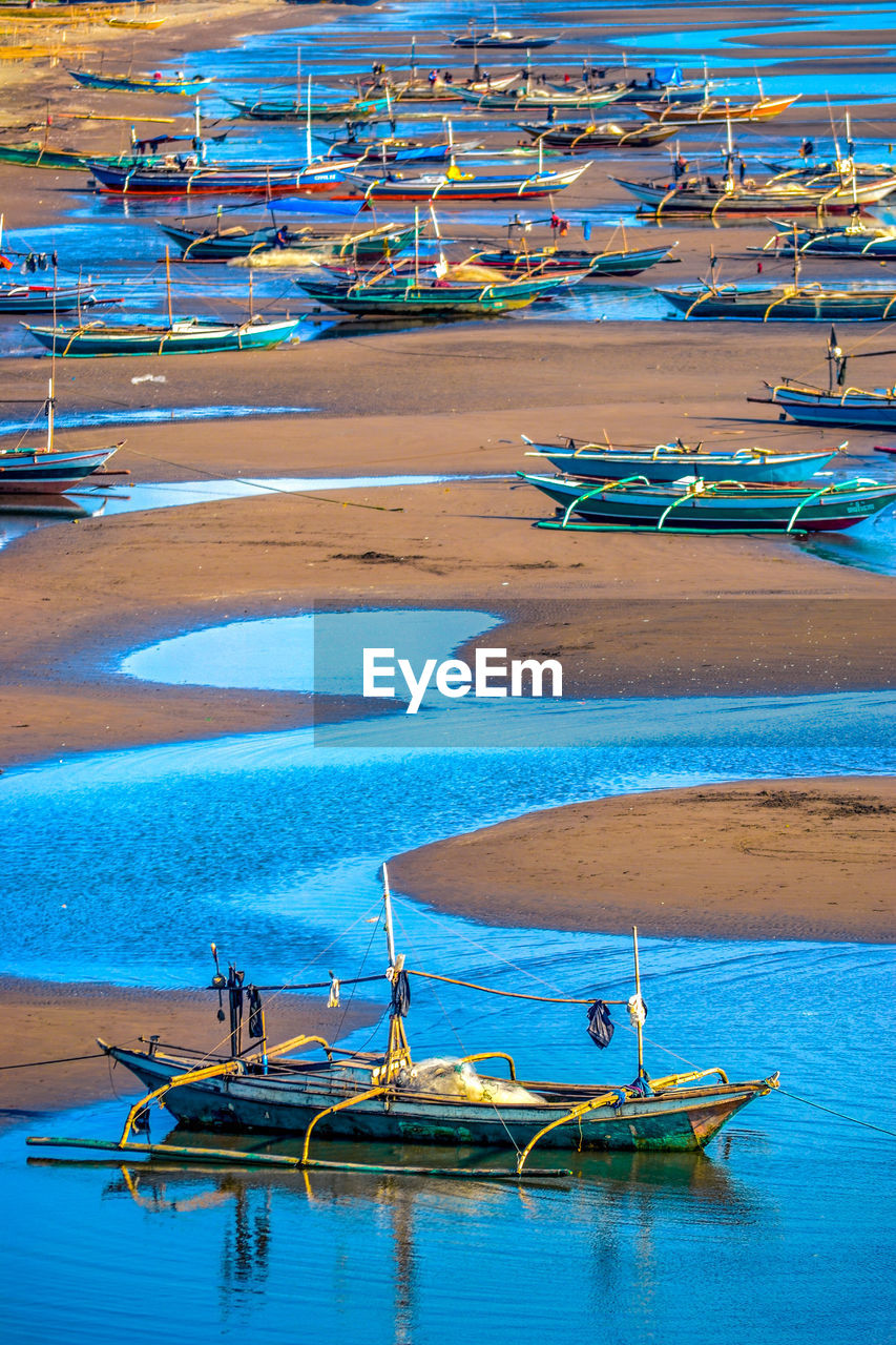 HIGH ANGLE VIEW OF BOATS MOORED AT SEA