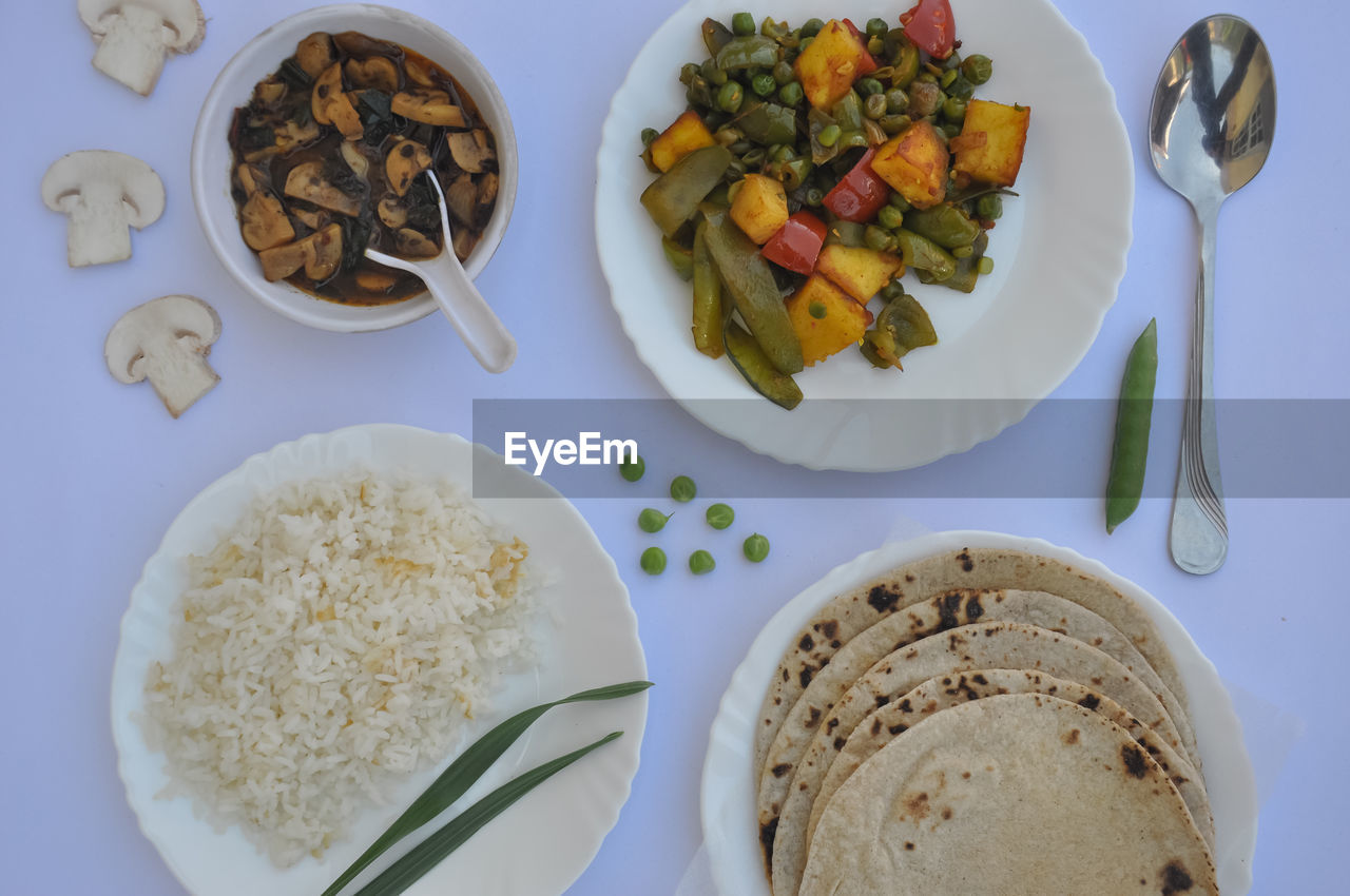 Top view of matar paneer veg, mashroom soup, roti and rice isolated over white background 