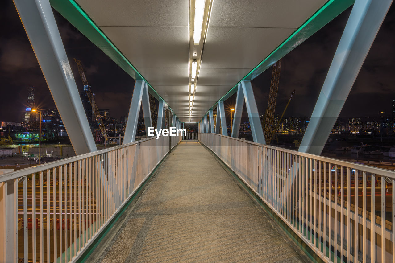 Empty illuminated footbridge in city