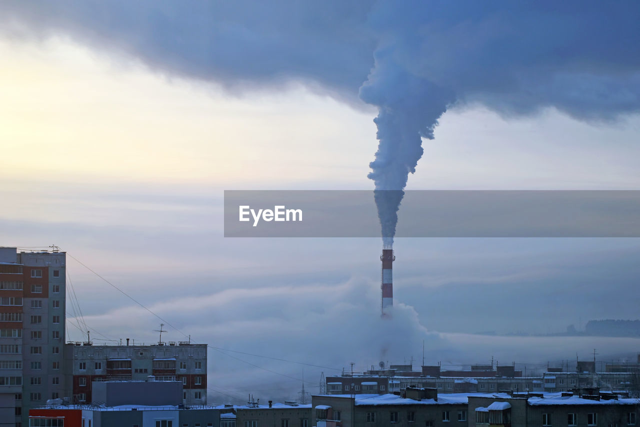 Smoke emitting from chimney against sky