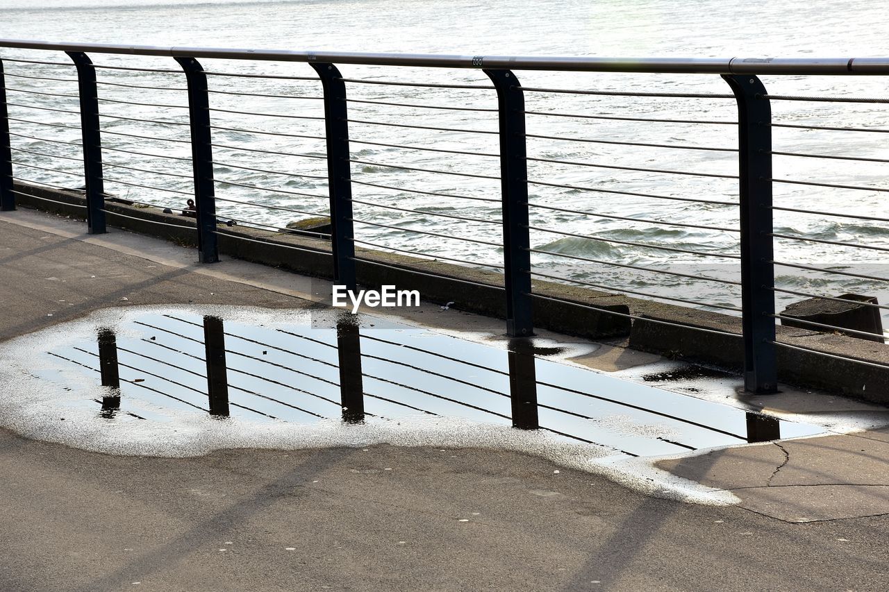 RAILING BY SEA AGAINST SKY