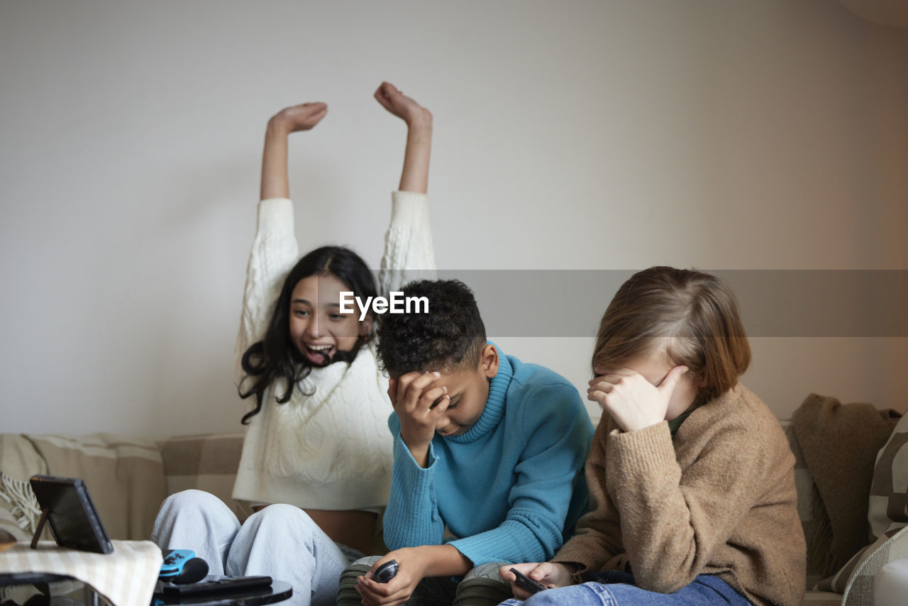 Children playing video games at home and celebrating