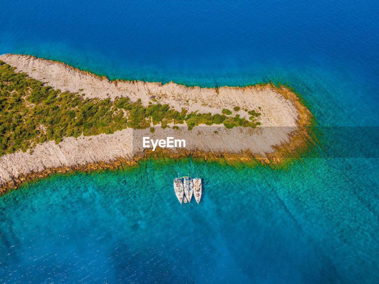 Overhead aerial view of sailing yachts anchored in a remote bay in croatia.