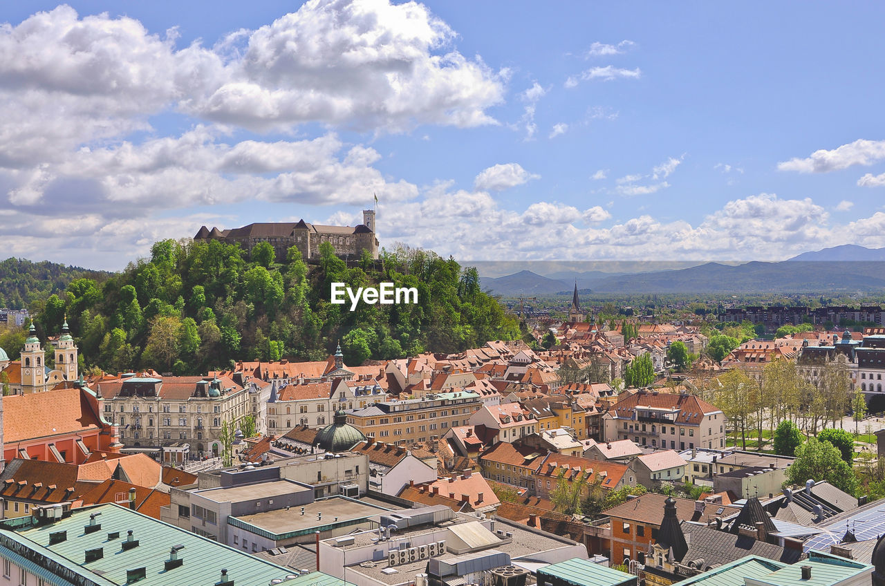 VIEW OF TOWN AGAINST CLOUDY SKY