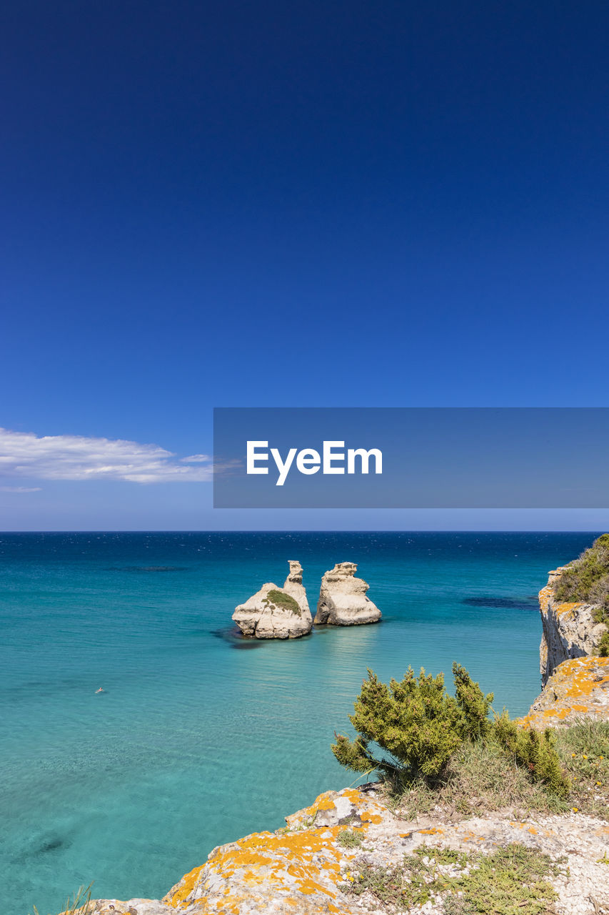 SCENIC VIEW OF ROCKS IN SEA AGAINST SKY