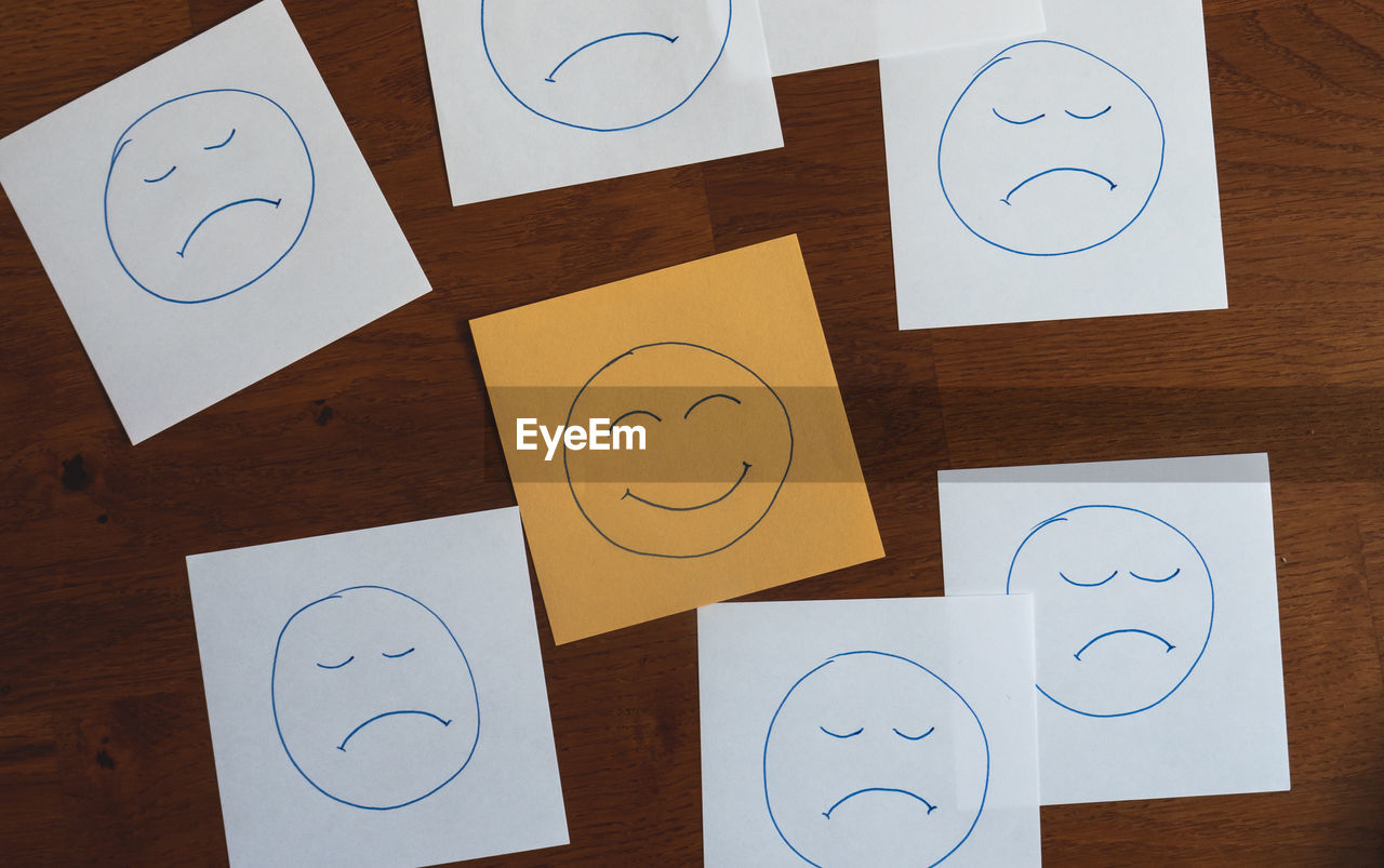Close-up of text notes with happy face among sad faces