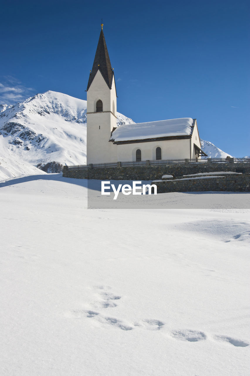 Church on snowcapped mountain against sky