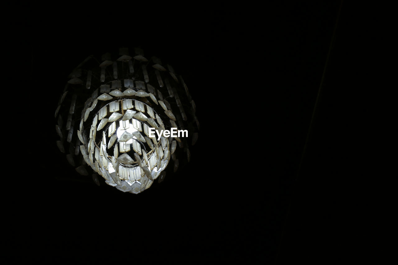 LOW ANGLE VIEW OF ILLUMINATED ELECTRIC LAMP AGAINST DARK BACKGROUND