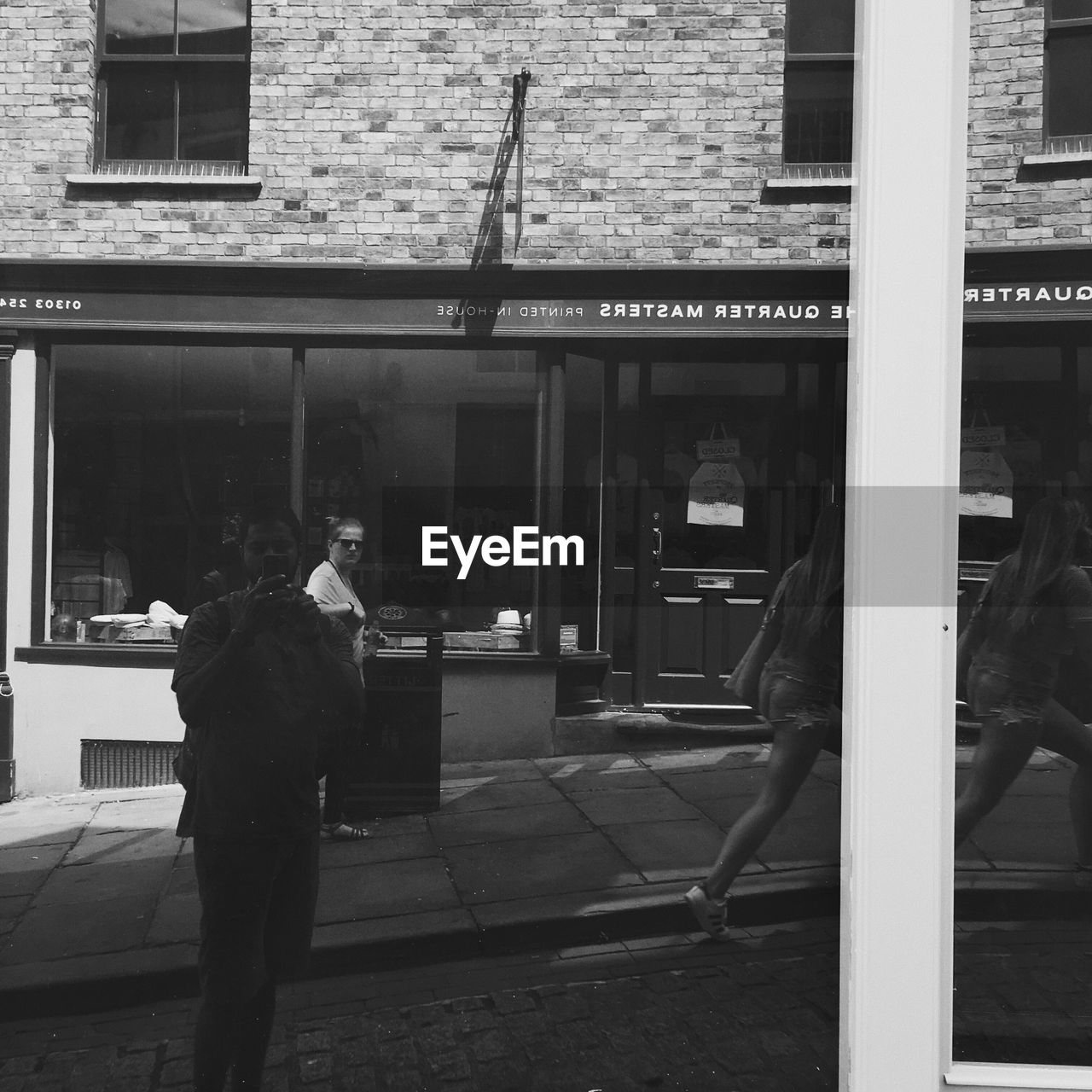 REAR VIEW OF MAN WALKING IN FRONT OF OFFICE BUILDING