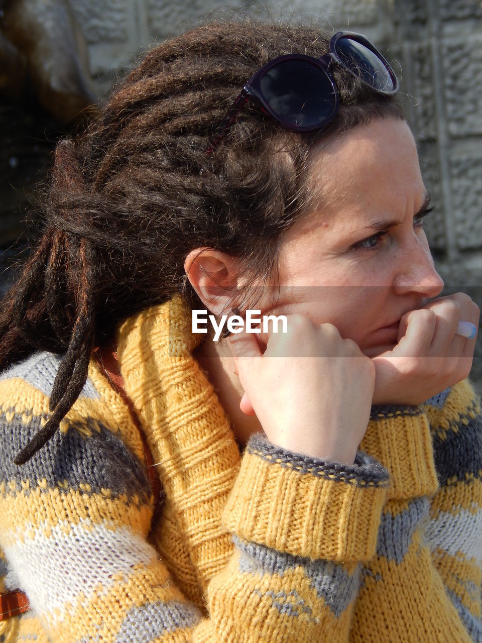 Thoughtful woman with dreadlocks looking away