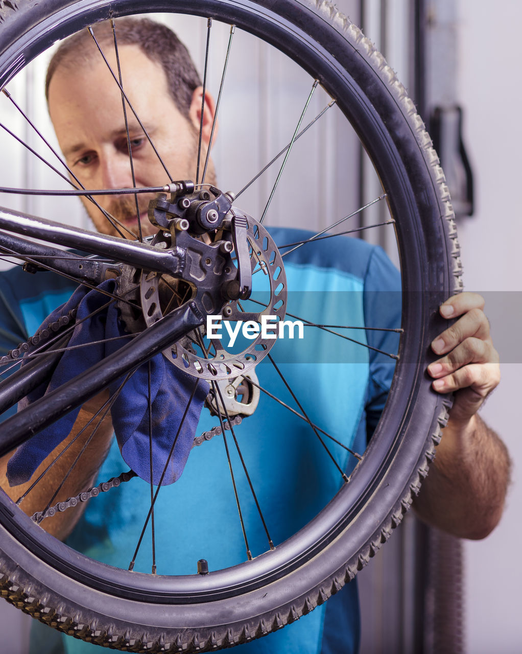 Mid adult man repairing bicycle at garage