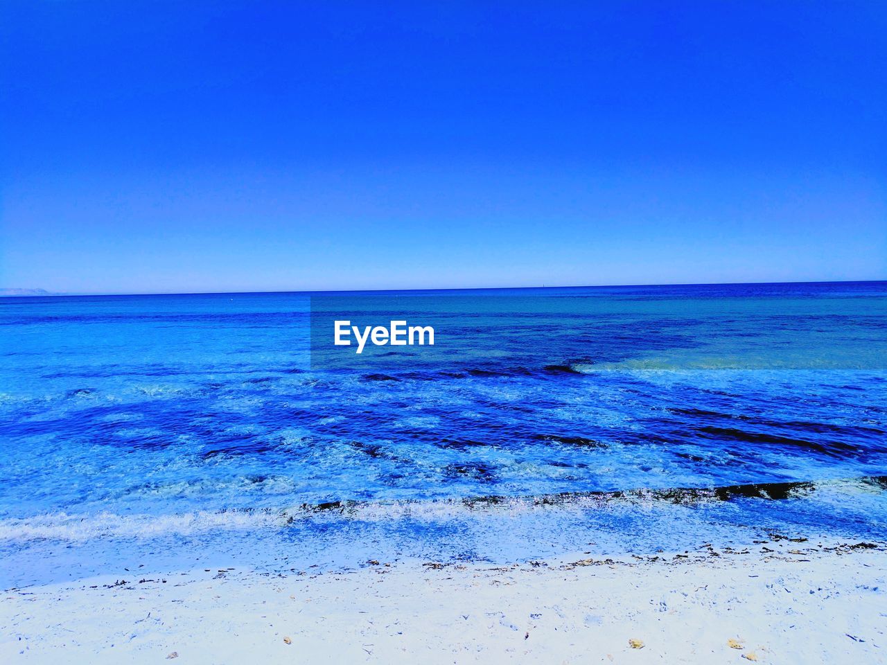 Scenic view of sea against clear blue sky