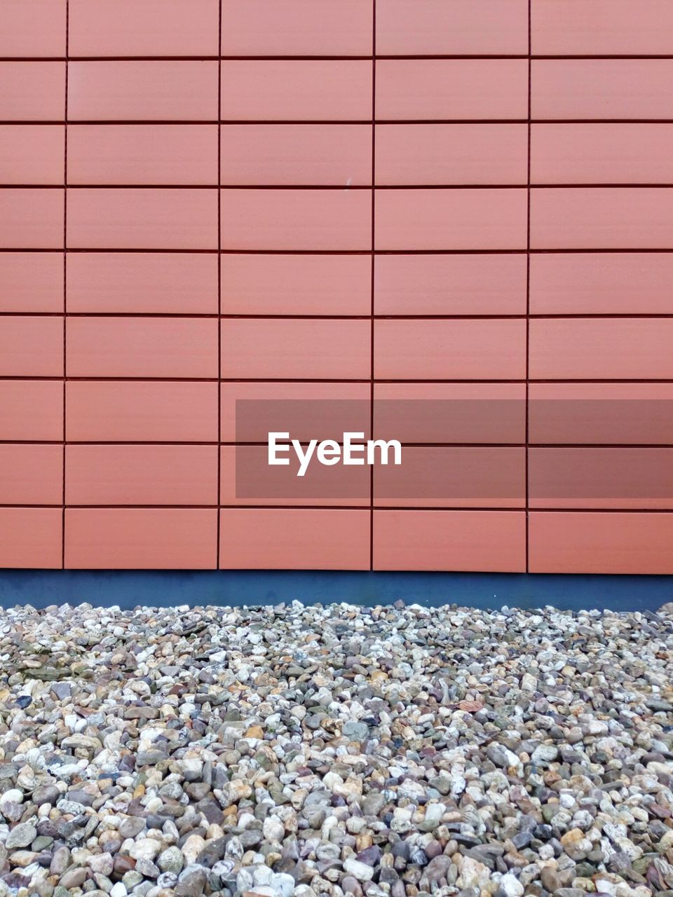 Pebbles and red tiled wall facade