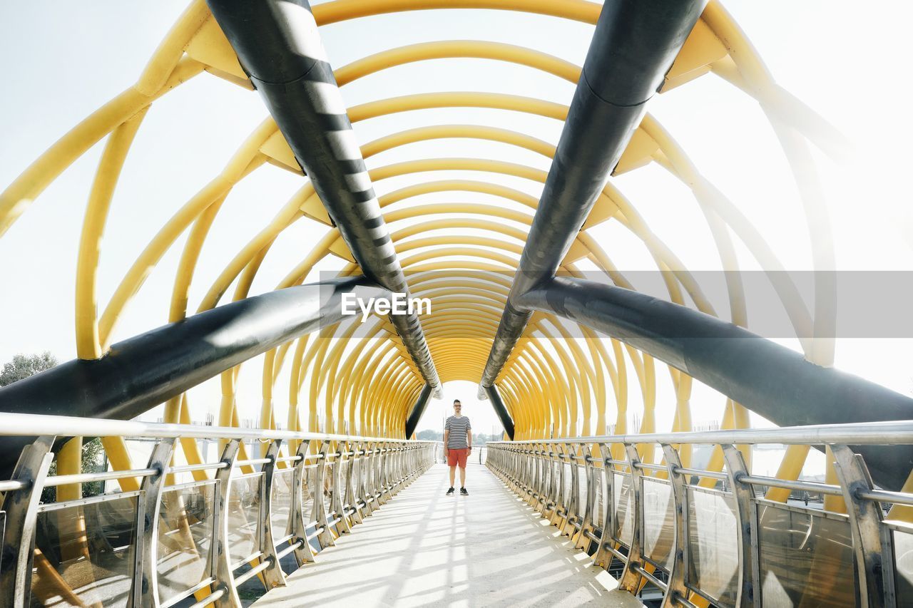 Man standing on covered bridge in city