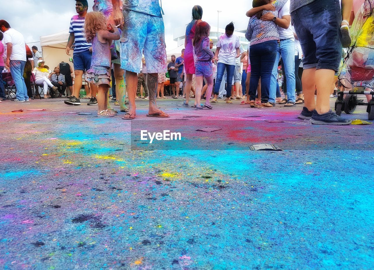 LOW SECTION OF PEOPLE STANDING BY MULTI COLORED STREET