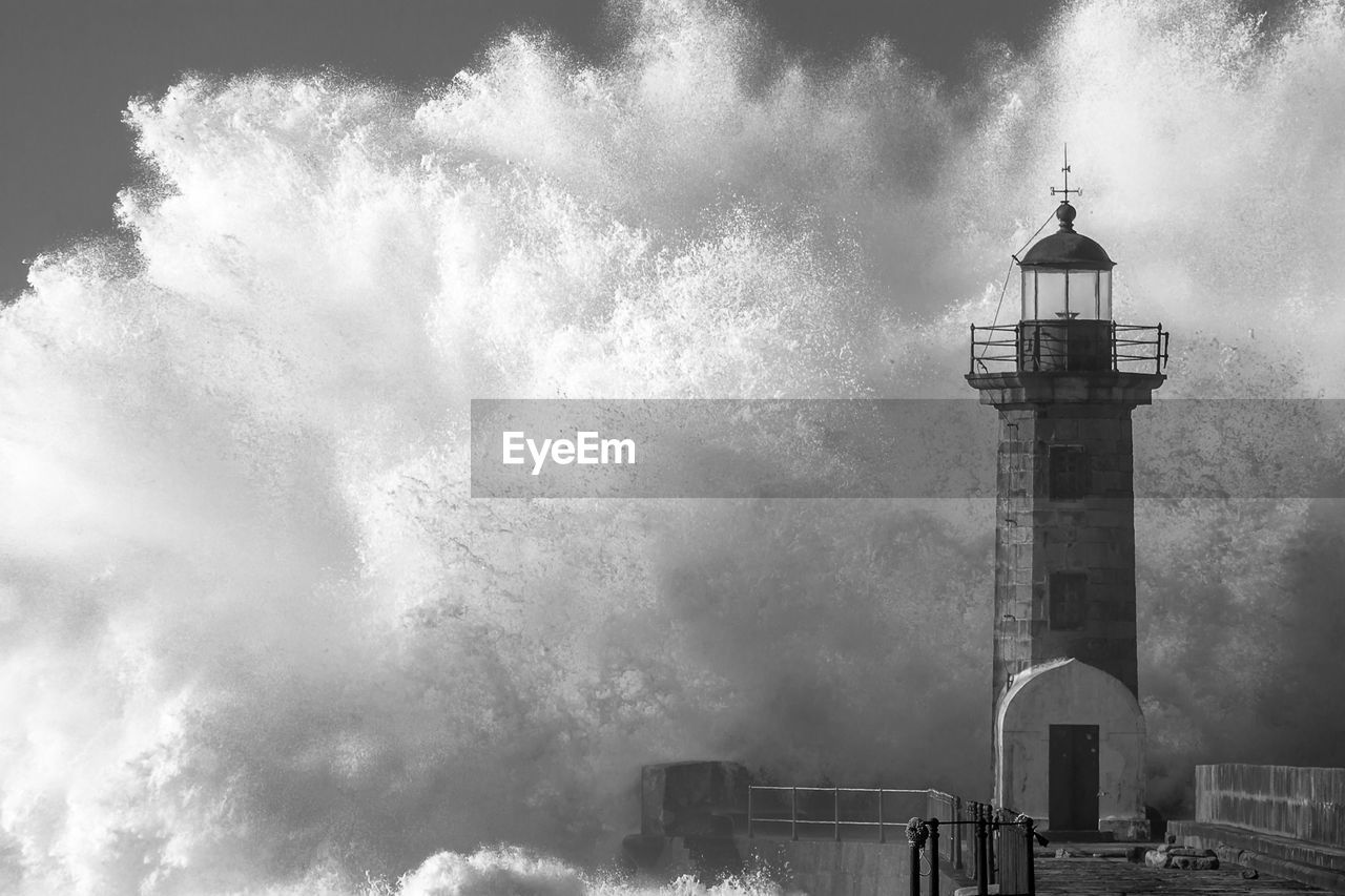 Majestic wave splashing on lighthouse during storm