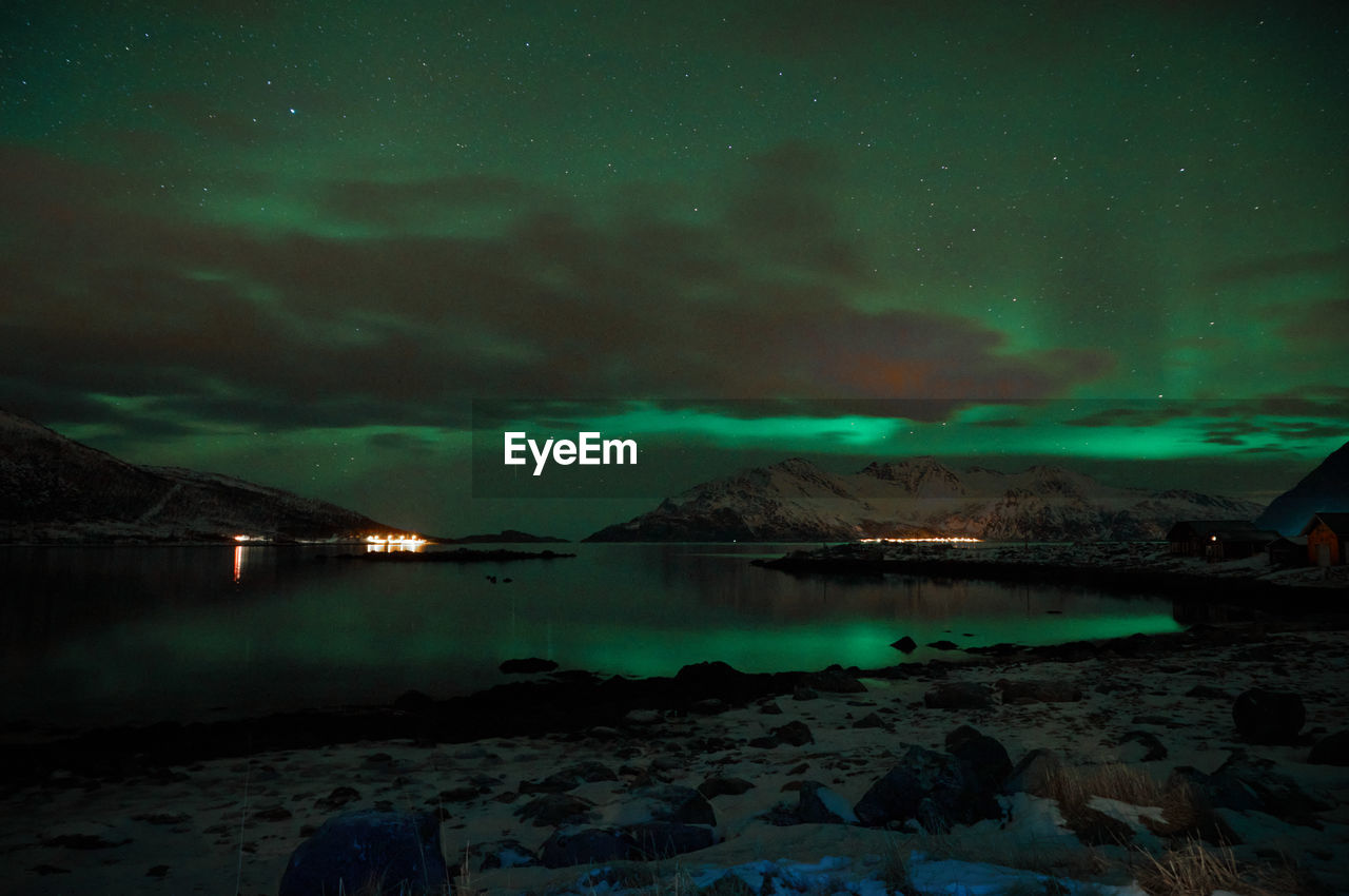 ILLUMINATED BEACH AGAINST SKY AT NIGHT