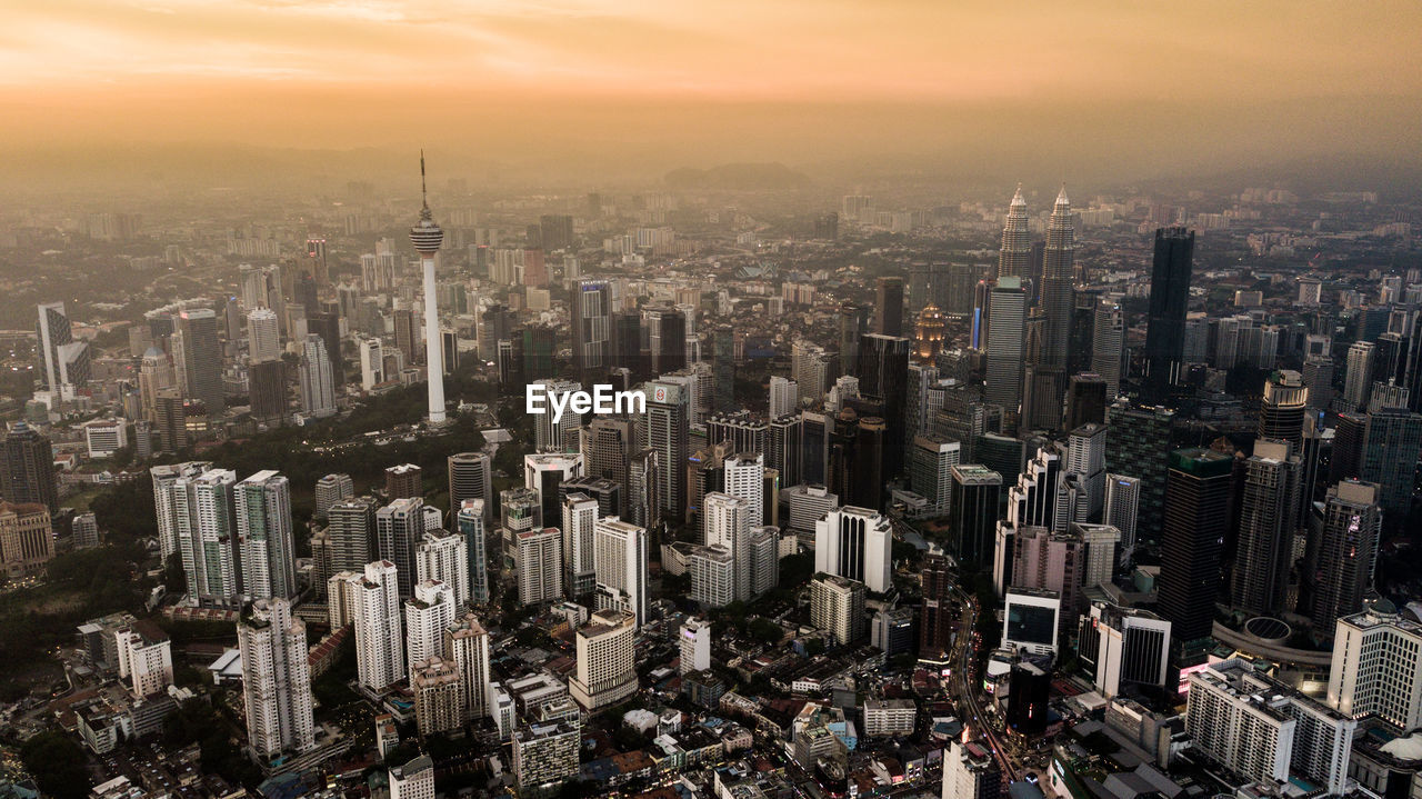 High angle view of modern buildings against sky during sunset