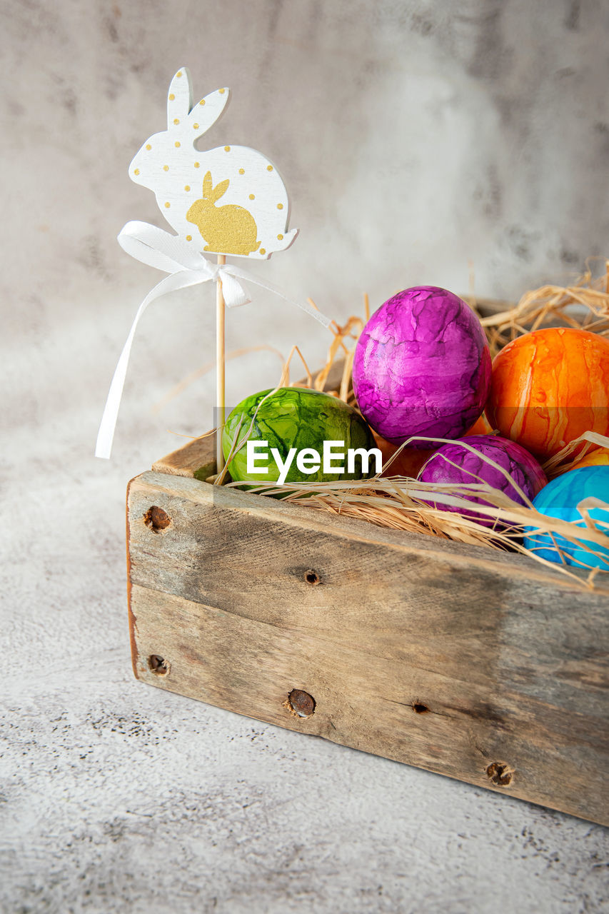 food, food and drink, easter, freshness, wood, celebration, still life, easter egg, no people, vegetable, tradition, multi colored, studio shot, egg, nature, plant, flower, yellow, healthy eating, holiday, indoors, wellbeing, container, springtime, basket, decoration, flowering plant, table, copy space