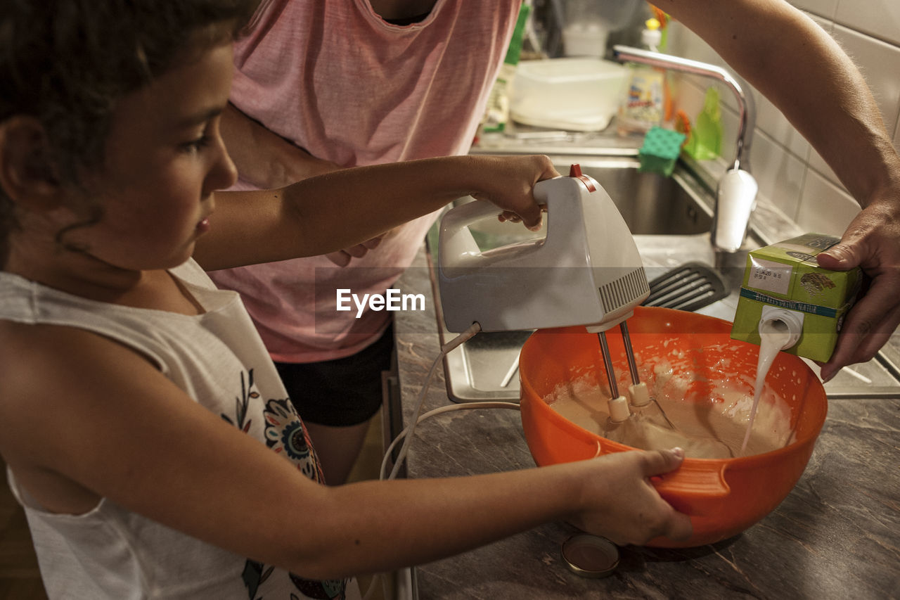 Girl making pancakes in kitchen at home