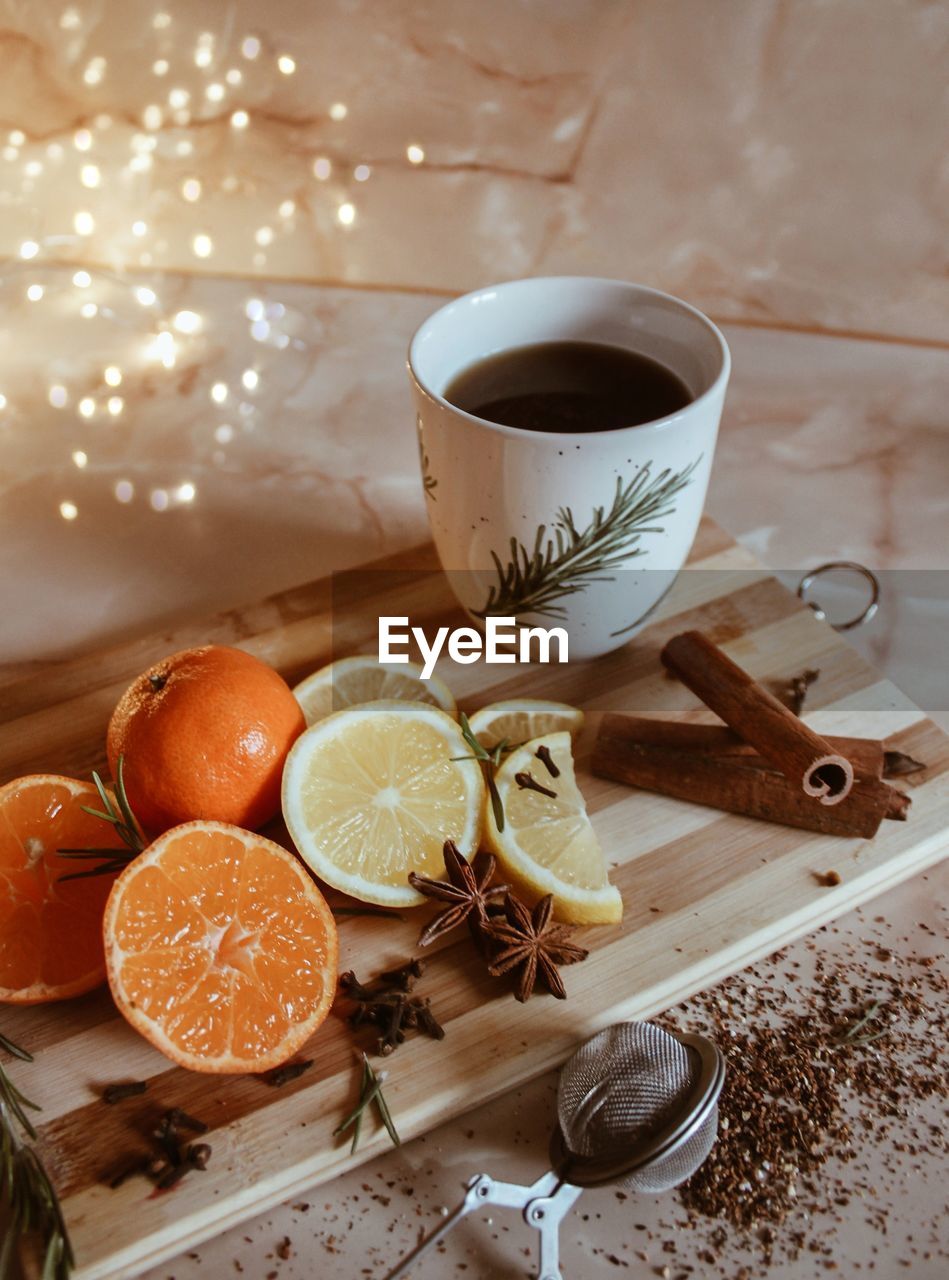 High angle view of fruits by coffee cup on table