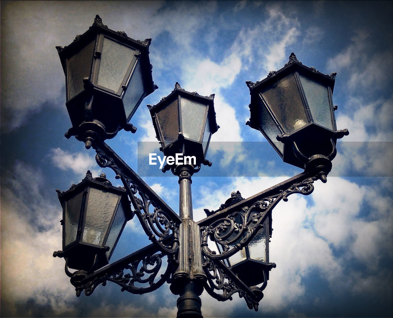 Low angle view of street light against cloudy sky