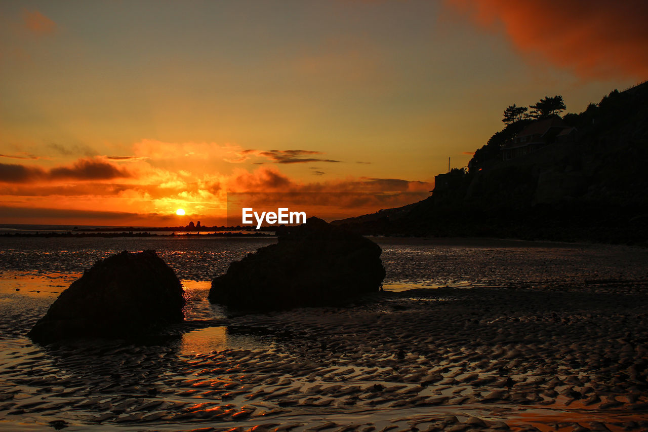 Scenic view of sea against orange sky