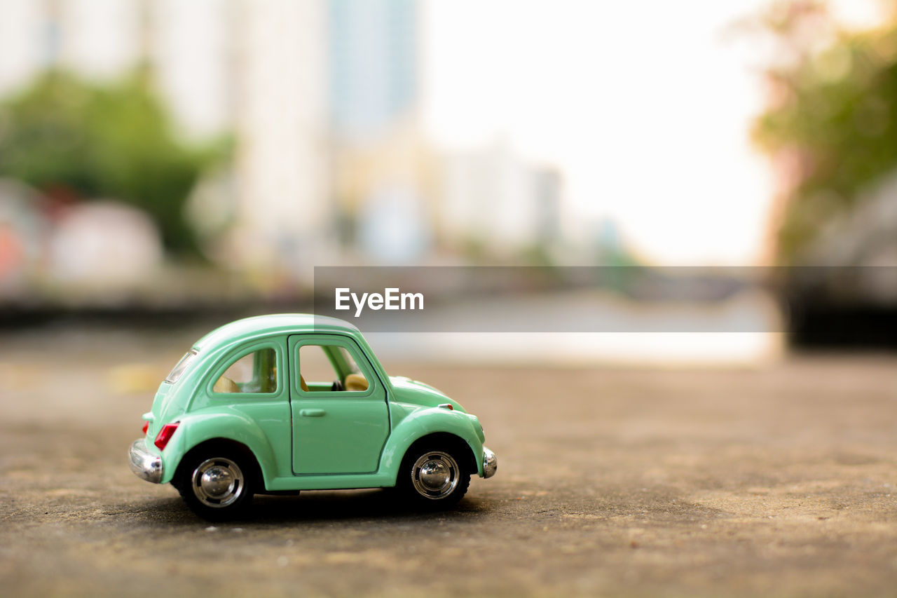 CLOSE-UP OF TOY CAR ON THE ROAD