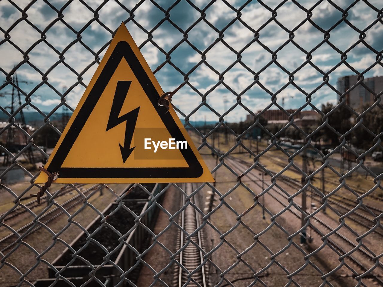 Close-up of warning sign on chainlink fence