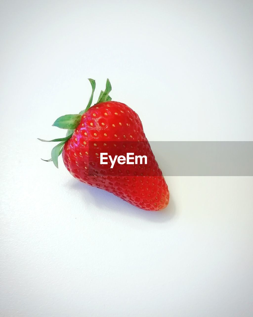 CLOSE-UP OF STRAWBERRY OVER WHITE BACKGROUND