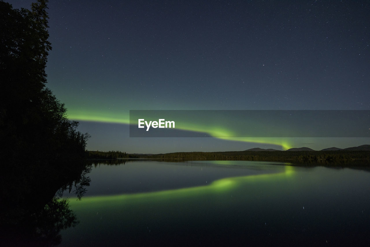 Scenic view of lake against sky at night