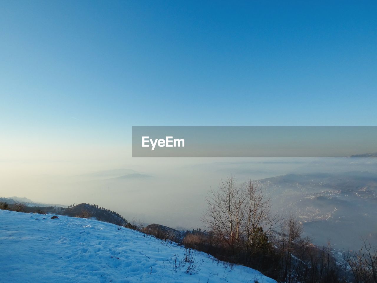 Scenic view of snow covered landscape against clear blue sky