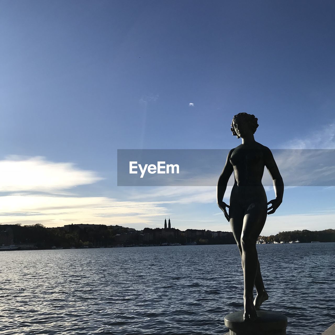 FULL LENGTH OF MAN STANDING AT SEA AGAINST SKY