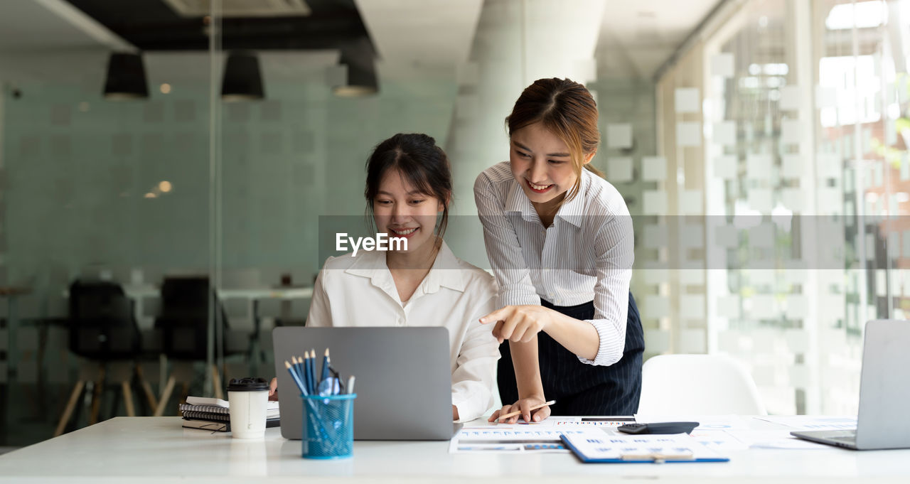 Smiling businesswomen brainstorming at office