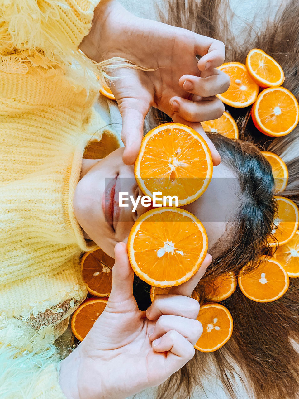 High angle view of woman holding orange fruit