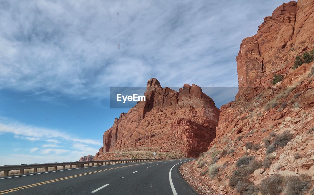 Landscape of road leading up between red cliffs in arizona