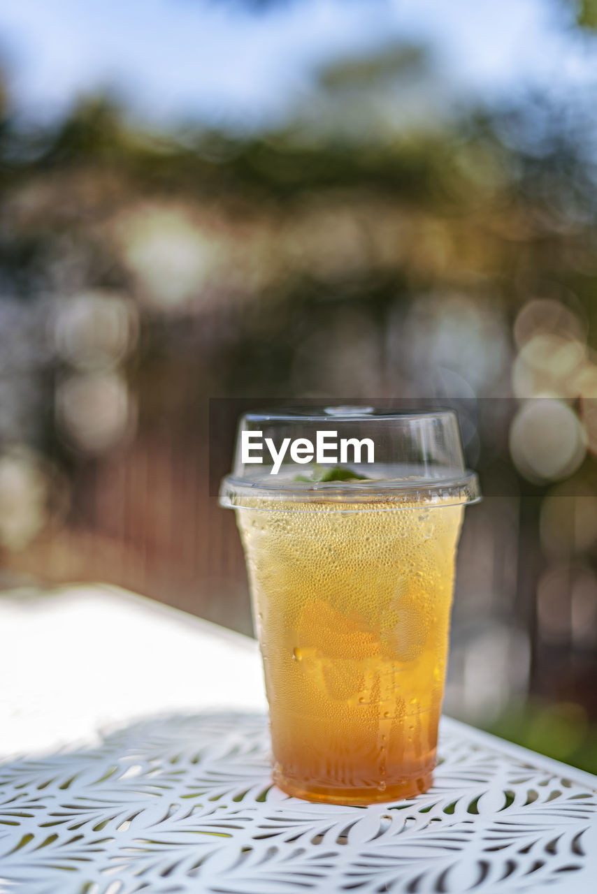 CLOSE-UP OF DRINK ON GLASS TABLE