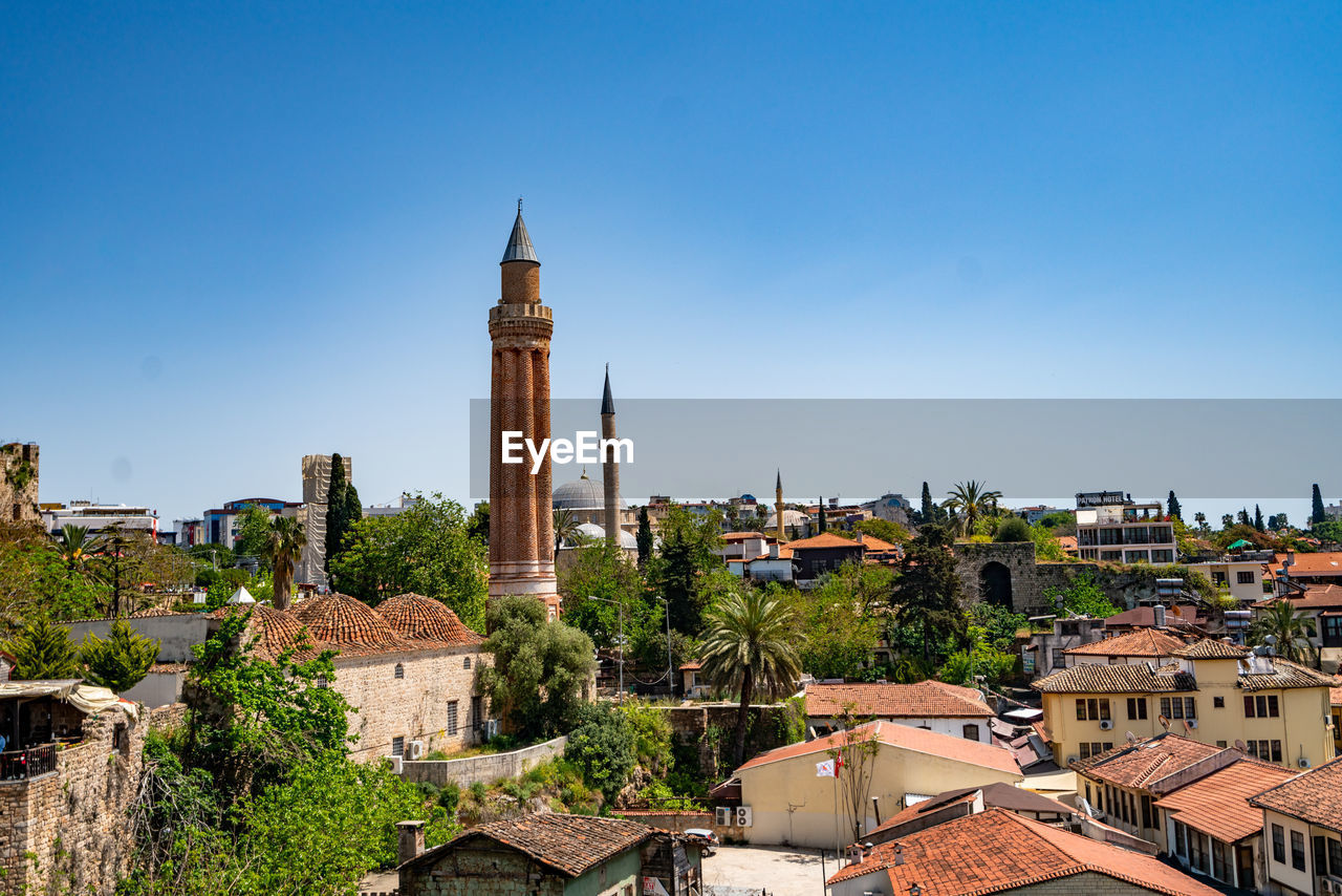 high angle view of buildings in city against clear blue sky