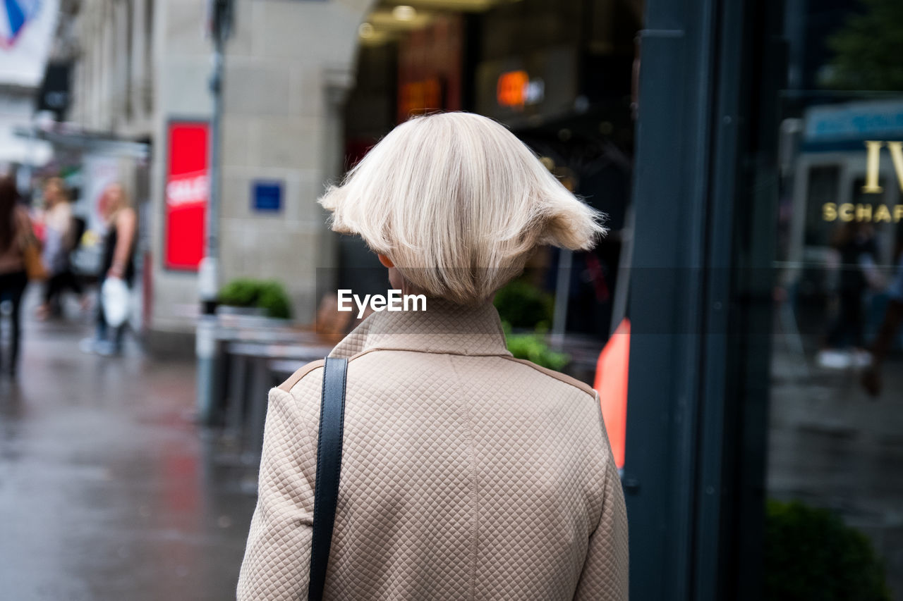 REAR VIEW OF WOMAN IN STREET