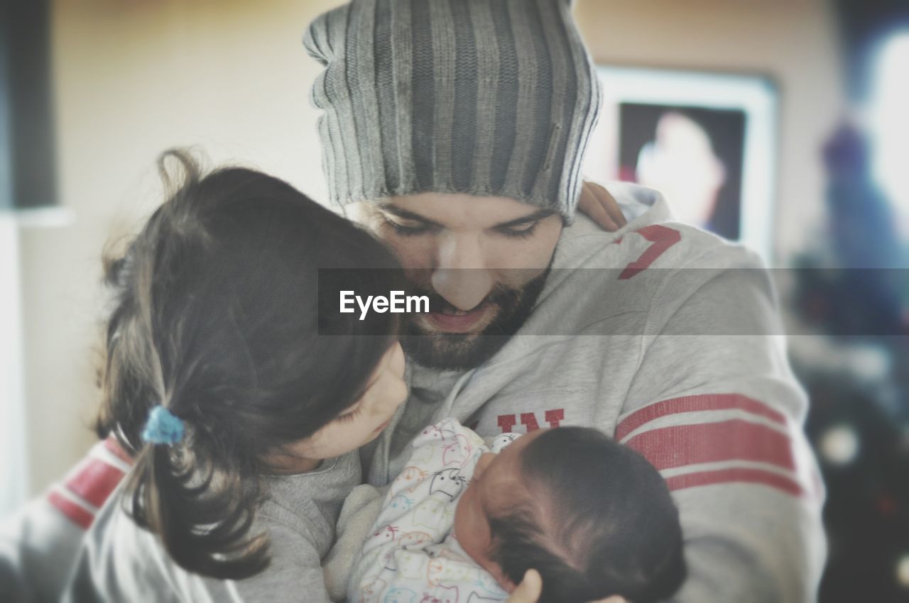 Close-up of father with daughter and new born baby boy