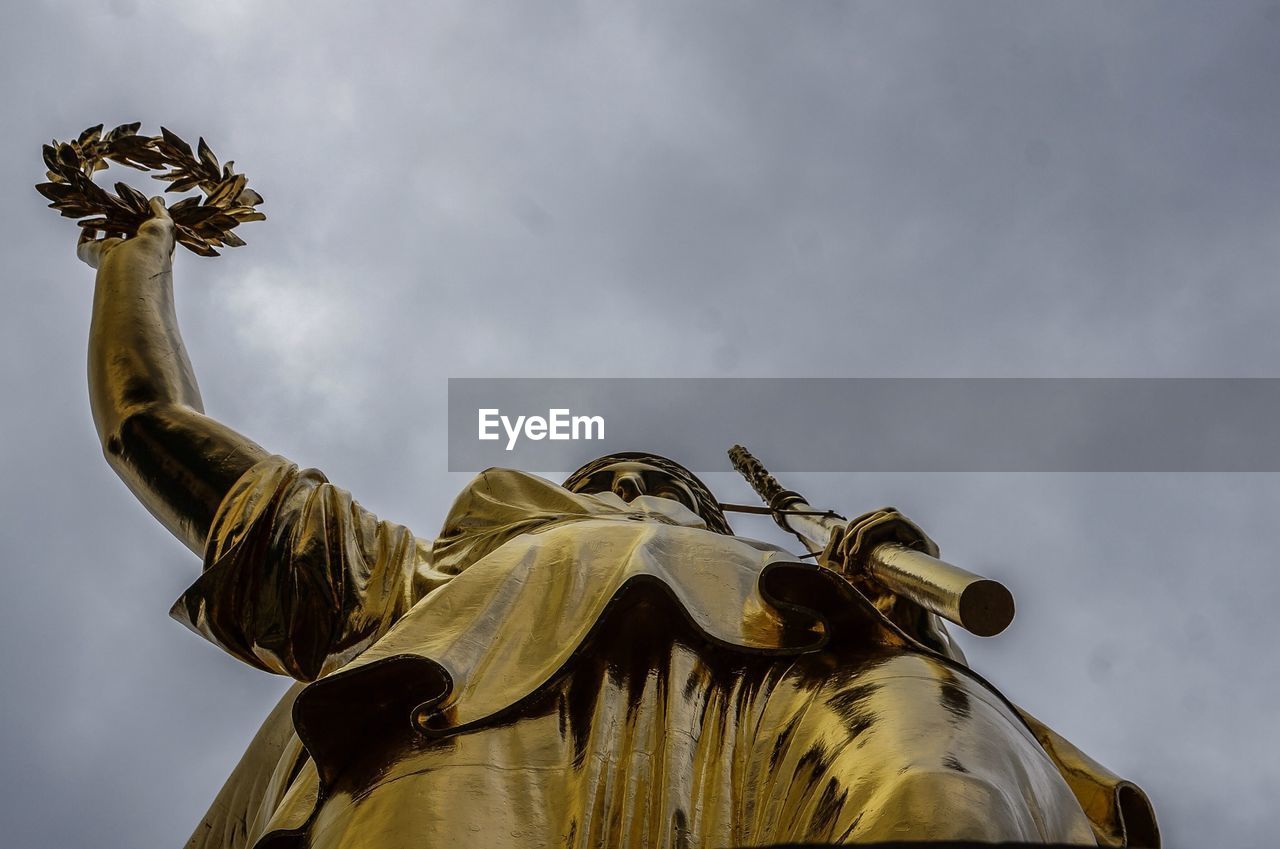 Low angle view of victory column against cloudy sky