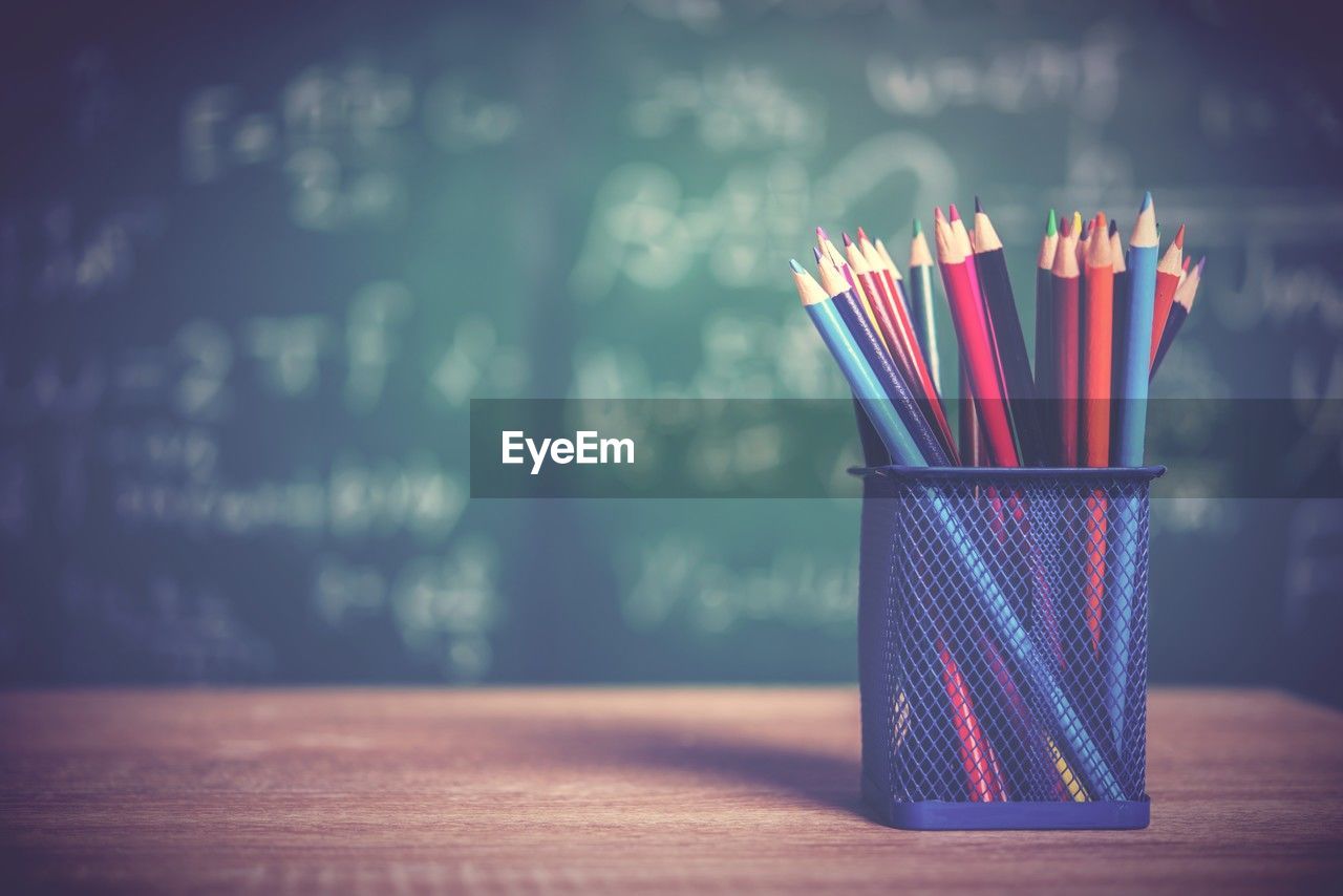 close-up of multi colored pencils in container on table