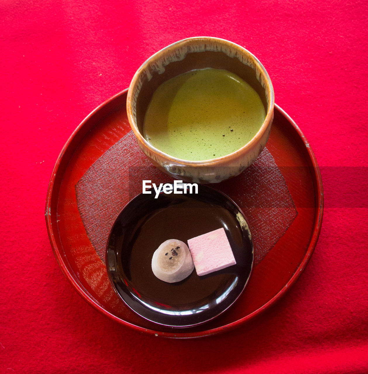 High angle view of tea cup and dessert on wooden plate