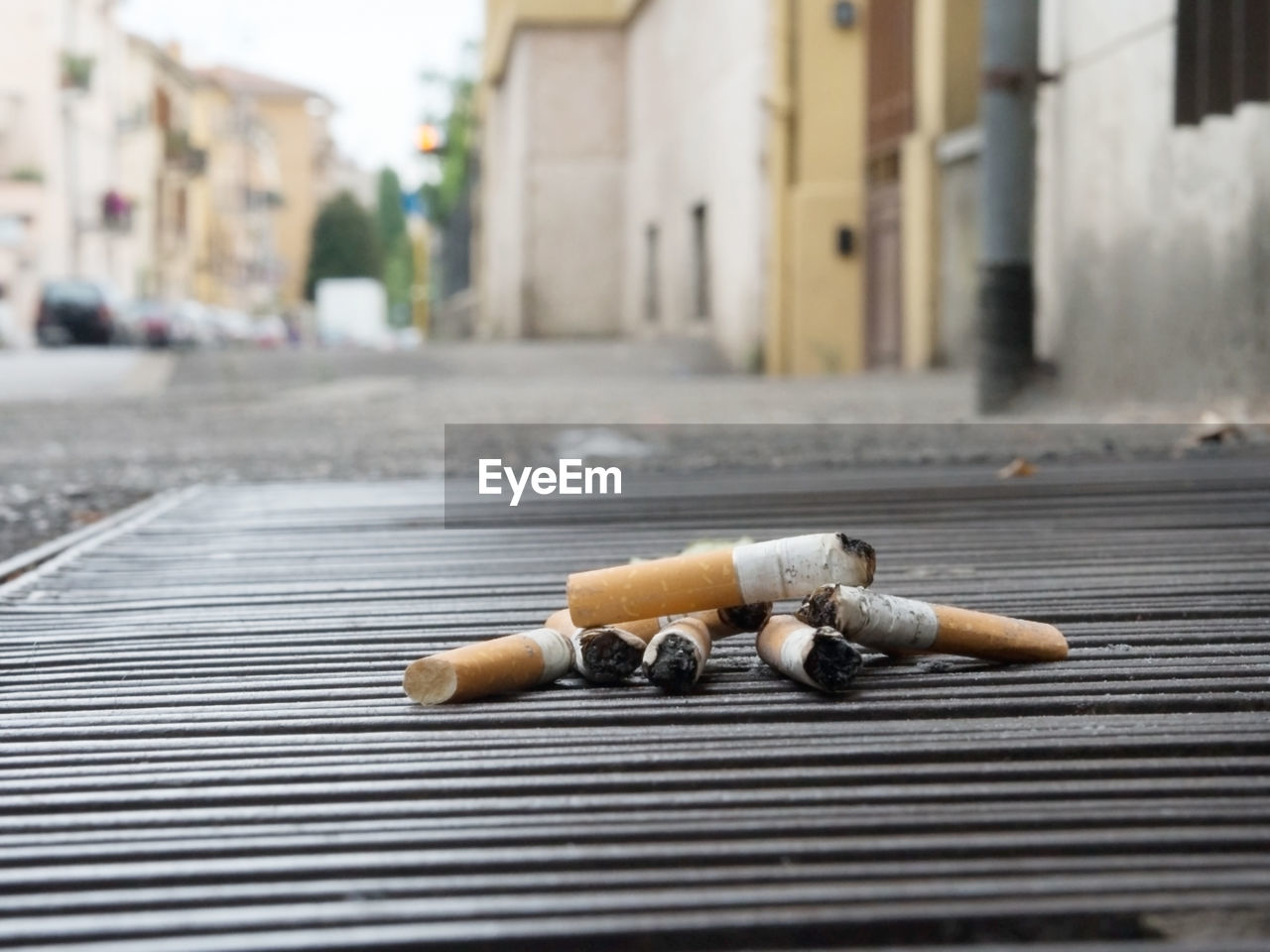 Close-up of cigarette butts on manhole