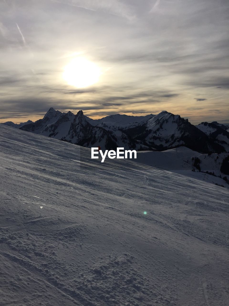 Scenic view of snow covered mountains against sky during sunset