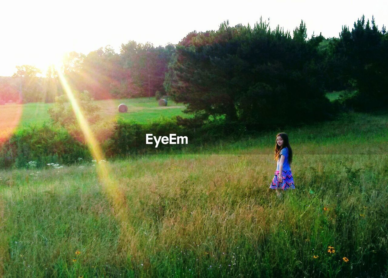 FULL LENGTH OF WOMAN STANDING ON FIELD